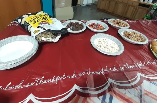 Various bowls of snacks on a table.