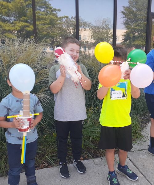Childen doing an egg-drop science experiment.