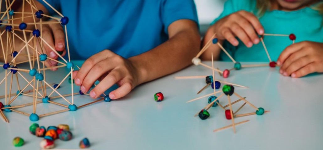 Children bulding structures with toothpicks and clay.